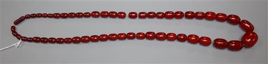 A single strand graduated simulated cherry amber necklace, gross weight 119 grams, approx. 90cm.